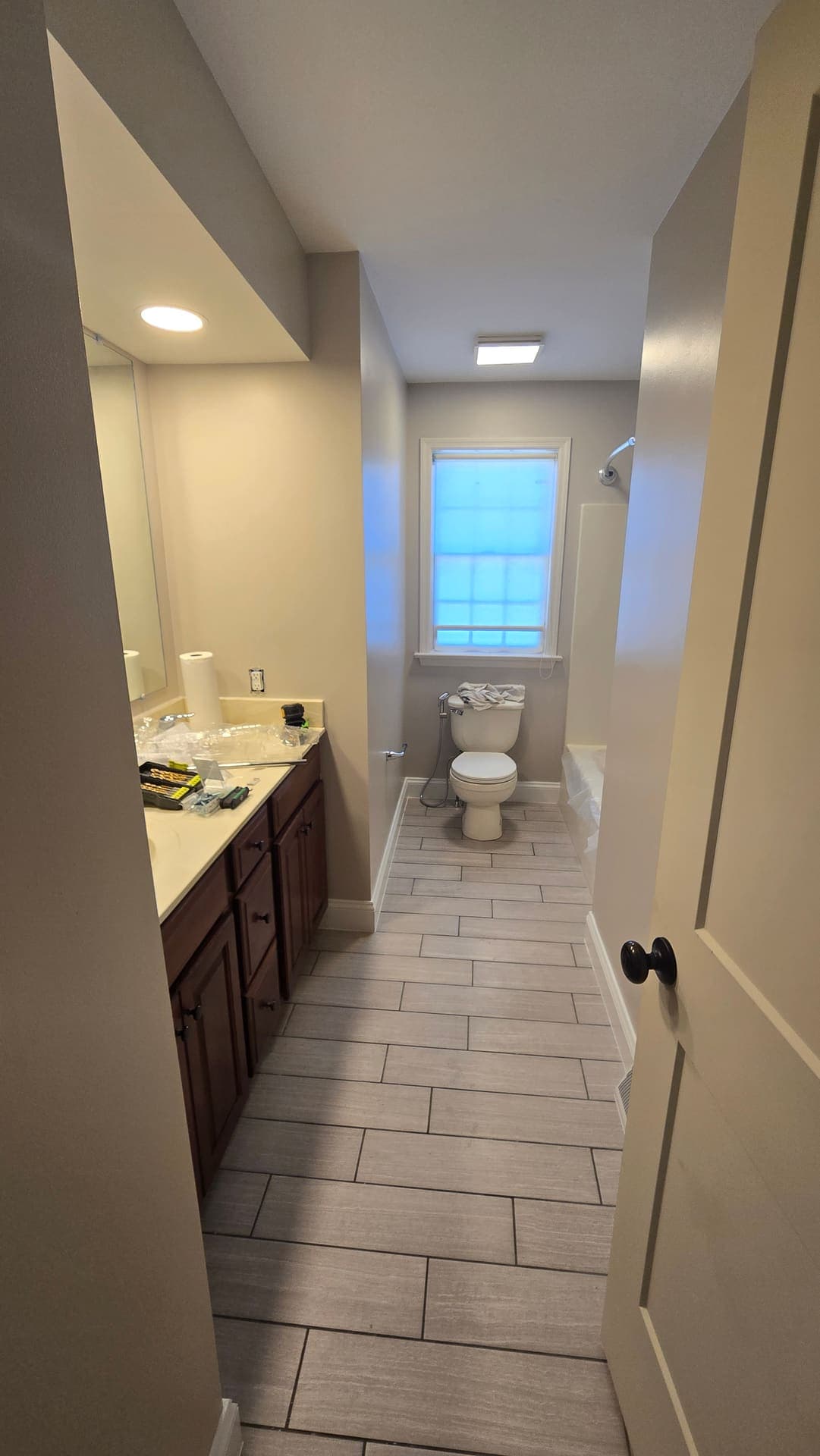 Wood look tile floor installation in a bathroom remodel