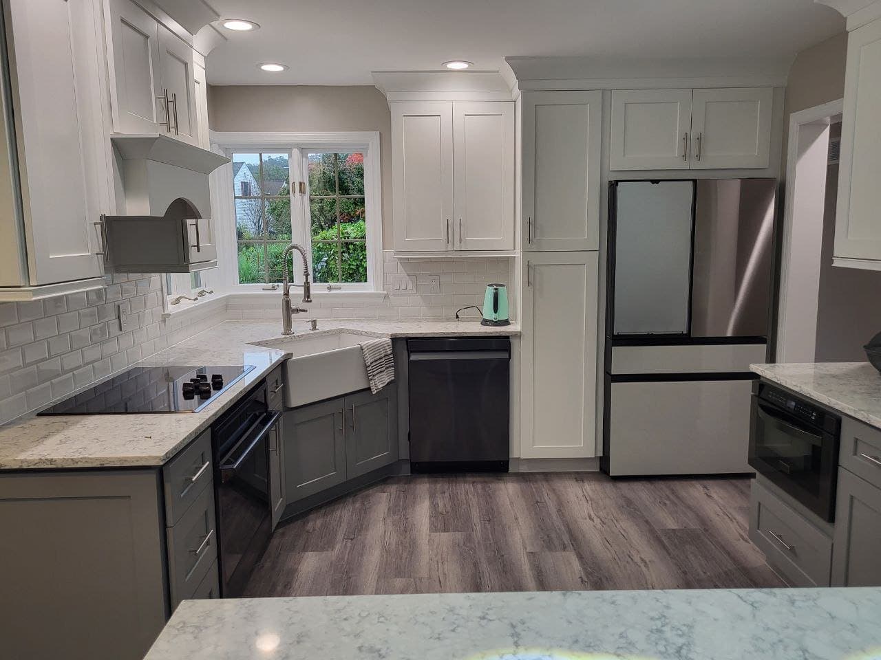 Remodeled kitchen with white cabinets, quartz counters and farmhouse sink