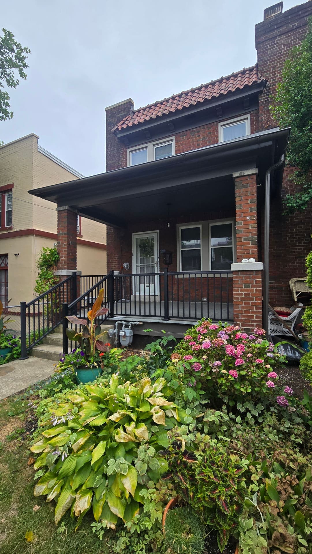 New black porch railings beside blooming hydrangeas