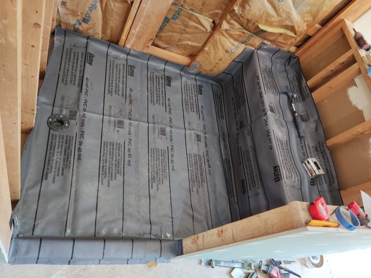 PVC shower pan liner installed in a framed shower stall