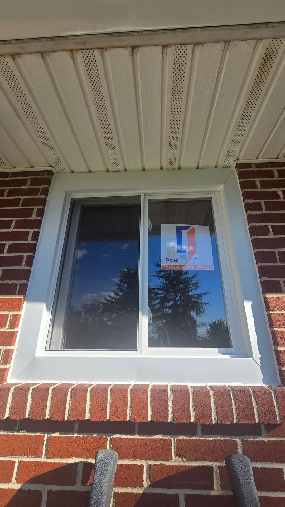 New white double hung window on brick and siding